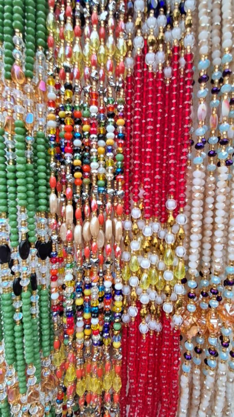 Puede incluir: Una variedad de collares de cuentas coloridas con diferentes texturas y patrones. Los collares est&aacute;n hechos de cuentas de vidrio, cuentas de madera y cuentas de metal. Algunos de los collares tienen un acabado dorado.