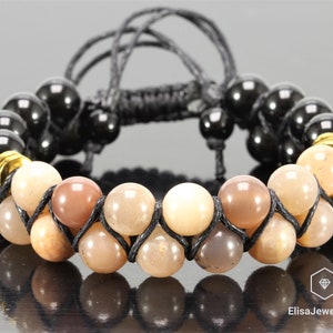 May include: A braided bracelet with black and gold beads and a double row of light brown beads.