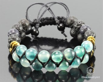 May include: A black cord bracelet with green and blue agate beads and black lava rock beads. The bracelet has gold accents.