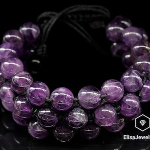 Op de afbeelding: Een armband met dubbele rij van amethist kralen en zwart koord. De armband is verstelbaar en kan aan beide polsen worden gedragen.
