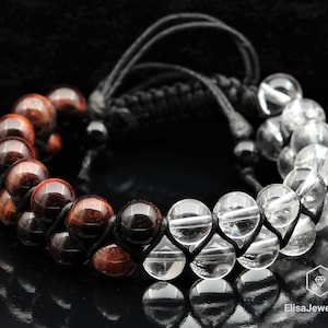 May include: A black cord bracelet with alternating red tiger's eye and clear quartz beads.
