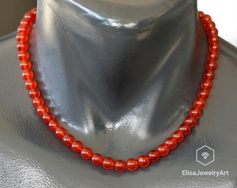 May include: A red carnelian bead necklace on a mannequin. The necklace is made of round beads and is approximately 18 inches long.