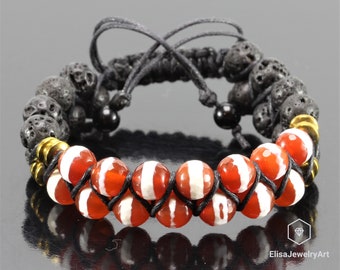 May include: A black cord bracelet with red and white agate beads and black lava rock beads. The bracelet has gold accents.