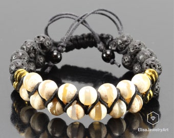 May include: A black lava rock and white agate beaded bracelet with gold spacers and black cord. The bracelet is adjustable with a sliding knot.