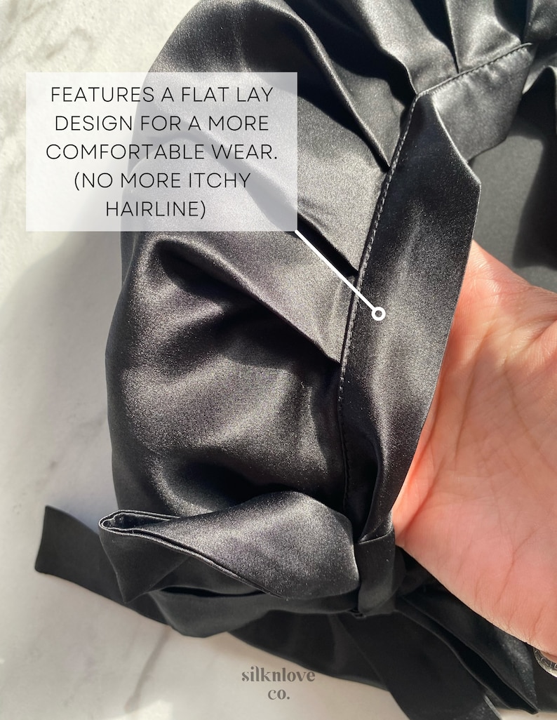May include: Close-up of a black satin garment. The fabric has a subtle sheen and is gathered at the seams. Text on the image reads: "FEATURES A FLAT LAY DESIGN FOR A MORE COMFORTABLE WEAR. (NO MORE ITCHY HAIRLINE)". The brand name "silknlove co." is also visible.