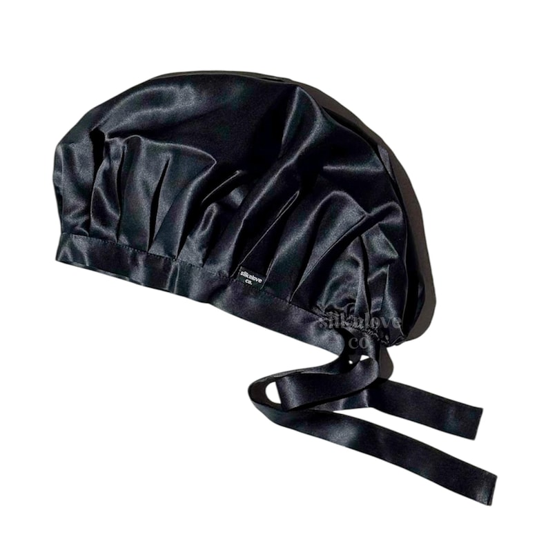 May include: Black satin sleep cap with a gathered top and two long ties. The cap has a small label that says "silklove co."