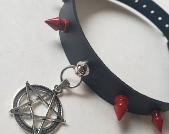 Gargantilla de cuero con púas rojas y colgante de pentagrama, estilo gótico punk.