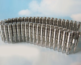 May include: A silver bullet belt made of linked bullet casings. The belt is made of metal and has a shiny finish.