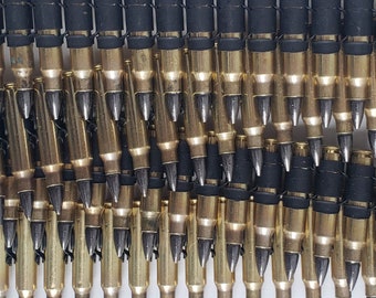 May include: A close-up of a metal belt of ammunition. The belt is made of linked brass cartridges with black rubber bands connecting them.
