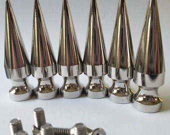 May include: Six silver metal spikes with a pointed tip and a rounded base. The spikes are 2.75 inches tall.