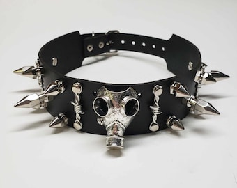May include: Black leather choker with silver spikes and a silver gas mask pendant.