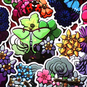 Puede incluir: Una colección de pegatinas coloridas con varios diseños florales, insectos y mariposas. Las pegatinas están impresas en papel blanco y tienen un acabado brillante.