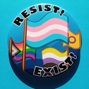 Könnte beinhalten: Ein blauer Knopf mit dem Text "Resist! Exist!" in Schwarz. Der Knopf zeigt vier Flaggen: eine Transgender-Pride-Flagge, eine Bisexuelle-Pride-Flagge, eine Pansexuelle-Pride-Flagge und eine Genderqueer-Pride-Flagge.
