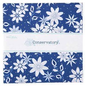May include: A blue fabric square with a white floral pattern and white polka dots. The fabric has a label that reads "Conservatory by Jill Finley of Jillily Studio".