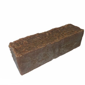 May include: A large, rectangular bar of brown soap. The soap has a rough, textured surface.