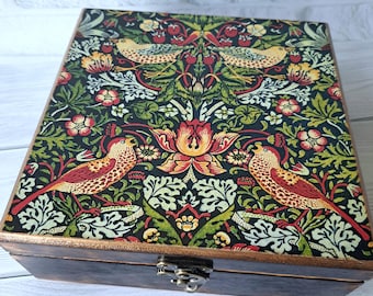May include: A wooden box with a hinged lid and a metal latch. The box is decorated with a colorful floral and bird pattern.
