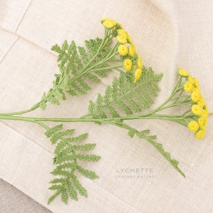 May include: A crocheted sprig of yellow flowers with green leaves on a beige linen background. The text "LYCHETTE CROCHET NATURE" is visible in the bottom right corner of the image.