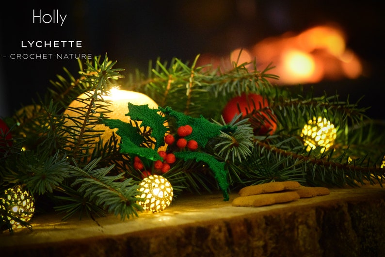 May include: A crocheted holly sprig with red berries, surrounded by evergreen branches and small, glowing, golden lights. The text "Holly" and "LYCHETTE - CROCHET NATURE" is visible in the image.