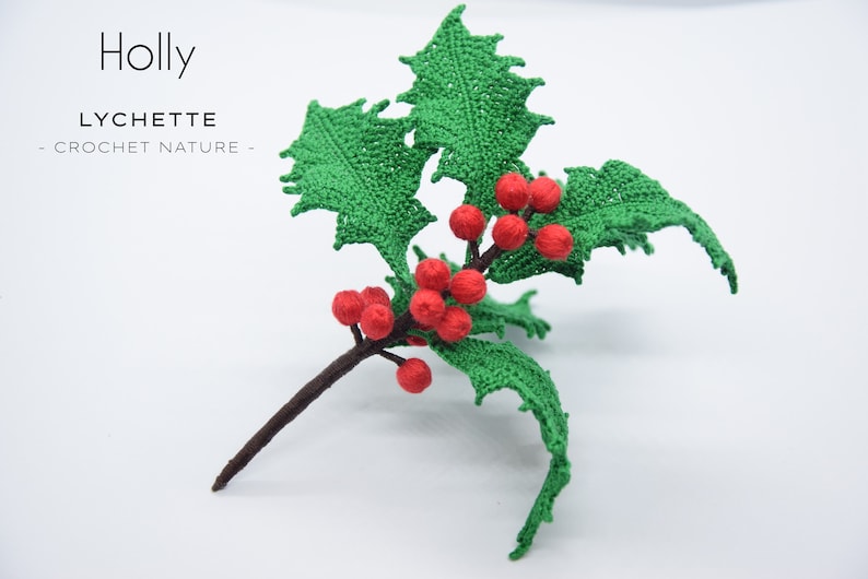 May include: A crocheted holly sprig with green leaves and red berries. The sprig is on a white background. The text "Holly" and "LYCHETTE - CROCHET NATURE -" is visible in the image.