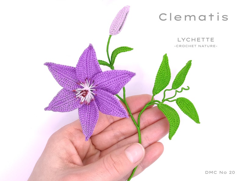 Puede incluir: Una flor de clem&aacute;tide de color p&uacute;rpura hecha a crochet con hojas verdes y un capullo. La flor se sostiene en una mano. El texto "Clematis" y "LYCHETTE -CROCHET NATURE- DMC No 20" es visible en la imagen.