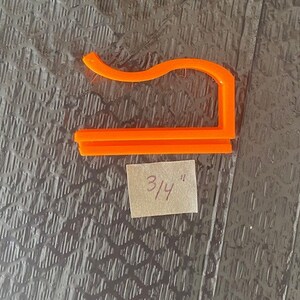May include: Orange plastic 3/4 inch hook for hanging items.