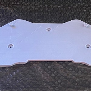 May include: A light gray plastic 3D printed part with five holes for screws. A small bag of screws is included.