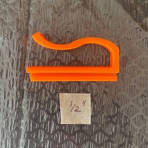 May include: Orange plastic 1/2 inch pipe clamp.