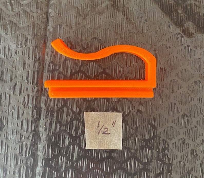May include: Orange plastic 1/2 inch pipe clamp.