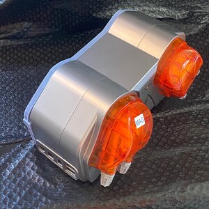 May include: A silver and orange dual-head dosing pump with the word "MAG" on one of the orange heads.