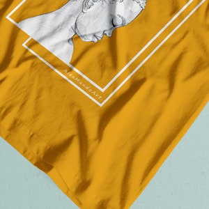 Puede incluir: Una camiseta amarilla con un contorno blanco de la cabeza y los hombros de una persona. El texto "AlexmundoArt" est&aacute; impreso en la camiseta.