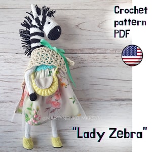 May include: Crochet pattern PDF for a "Lady Zebra" amigurumi doll. The zebra is wearing a floral dress, a green ribbon, a crocheted shawl, and a yellow crocheted bag. The pattern is available in English.