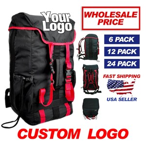 May include: Black backpack with red accents and adjustable straps. The backpack has a large main compartment and a smaller front pocket. The text "Your Logo" is printed on the front of the backpack. The text "WHOLESALE PRICE" is printed in red on a white background. The text "6 PACK", "12 PACK", and "24 PACK" are printed in black on a white background. The text "FAST SHIPPING" is printed in black on a white background. The text "USA SELLER" is printed in black on a white background. The text "CUSTOM LOGO" is printed in red on a white background.