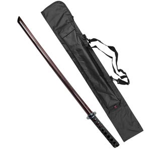May include: A black sword scabbard with a shoulder strap and a wooden katana sword with a black handle and a black and red wrapped grip.