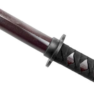 May include: Close-up of a wooden katana handle wrapped in black cord. The handle is dark brown and has a black plastic ring near the end.
