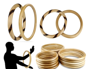 Op de afbeelding: Verschillende houten armbanden in verschillende opstellingen. Sommige armbanden hebben een natuurlijke houtnerf, terwijl andere een gestreept patroon in bruin en beige hebben. Een silhouet van een persoon die met een armband jongleert is ook inbegrepen.
