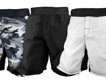 May include: Three pairs of athletic shorts in different colors and patterns. One pair is black, one is white with black accents, and one is camouflage with gray and black.