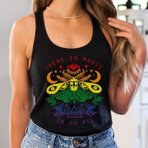 May include: A black tank top with a rainbow moth design and the text "There is magic in us all".