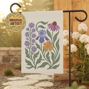 Peut inclure: Un drapeau de jardin crème avec un motif floral de fleurs violettes, bleues et orange, avec des feuilles vertes. Le drapeau est affiché sur un support en métal noir. Les mots "ORIGINAL ARTIST!" sont sur un autocollant circulaire.