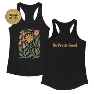 May include: Black racerback tank top with a floral design featuring a yellow daisy, pink bell-shaped flowers, and green leaves. The text "Be Pretti Good" is printed on the back. The words "ORIGINAL ARTIST!" are in a circular design.