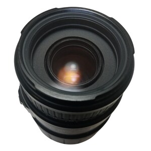 May include: A black camera lens with a wide aperture. The lens has multiple rings and a glass element that reflects light. The lens is designed for use with a digital camera.