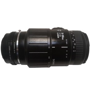 May include: A black Sigma 70-300mm f/4-5.6 macro zoom lens. The lens has markings for focal lengths, aperture settings, and a macro function. It features a Fotasy AF-FE mount and a lock/open mechanism.