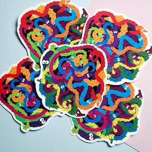 May include: Five colourful stickers featuring a design of a tangled group of worms with googly eyes. The worms are in a rainbow of colours, including red, orange, yellow, green, blue, purple, and black.