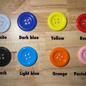 May include: Assortment of ten round buttons in various colors, including white, dark blue, yellow, red, black, light blue, orange, and pastel pink. Each button has four holes.