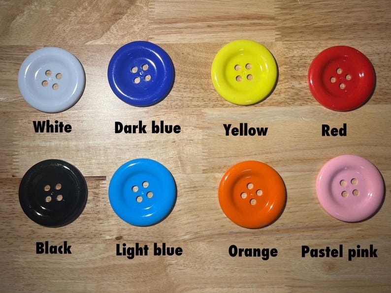 May include: Assortment of ten round buttons in various colors, including white, dark blue, yellow, red, black, light blue, orange, and pastel pink. Each button has four holes.