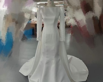 Minimalistisk, figursydd och utsvängd brudklänning med lång ärm
