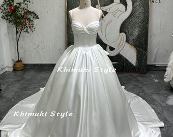 Vestido de novia de satén suave color marfil con escote en V y tirantes finos.