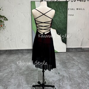 K&ouml;nnte beinhalten: Ein schwarzes und rotes Kleid mit Schn&uuml;rung am R&uuml;cken und einem Chiffonrock. Das Kleid befindet sich auf einer Puppe und der Hintergrund ist eine wei&szlig;e Wand.