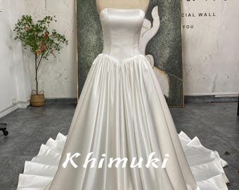 Vestido de novia de satén suave con cola larga y cintura en V.