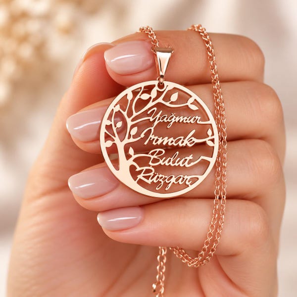 May include: A rose gold-toned circular pendant necklace featuring a cutout tree of life design. The branches of the tree incorporate four engraved names: Yağmur, Irmak, Bulut, and Rüzgar. The pendant hangs from a delicate matching rose gold-toned chain.