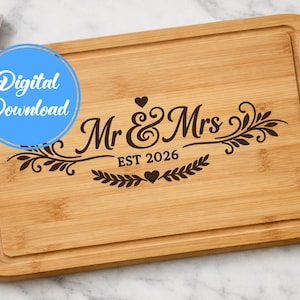 May include: A rectangular bamboo chopping board with a decorative border and engraved text. The text reads "Mr & Mrs EST 2026" with floral and heart accents. A blue circle with "Digital Download" is in the upper left. A knife is on the right.